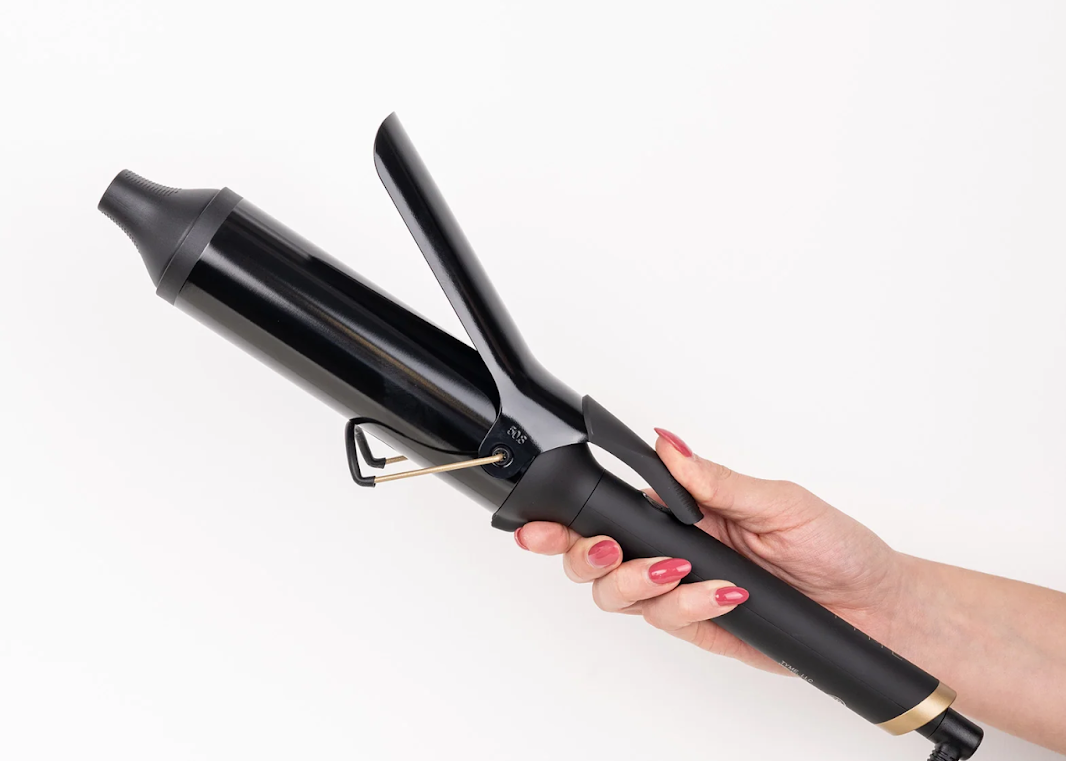 Image of a hand holding the TYME 2 Curling Iron.