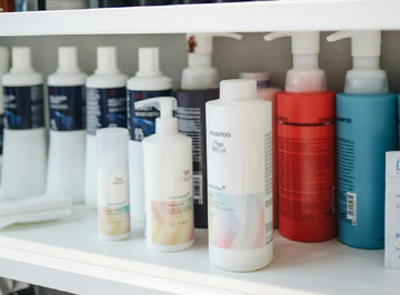 A shelf in a salon with hair products in a row